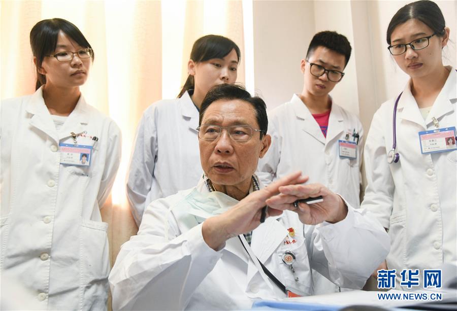 钟南山在广州医科大学附属第一医院的诊室内为患者分析病情(2018年8月2日摄)。 新华社记者 邓华 摄.jpg
