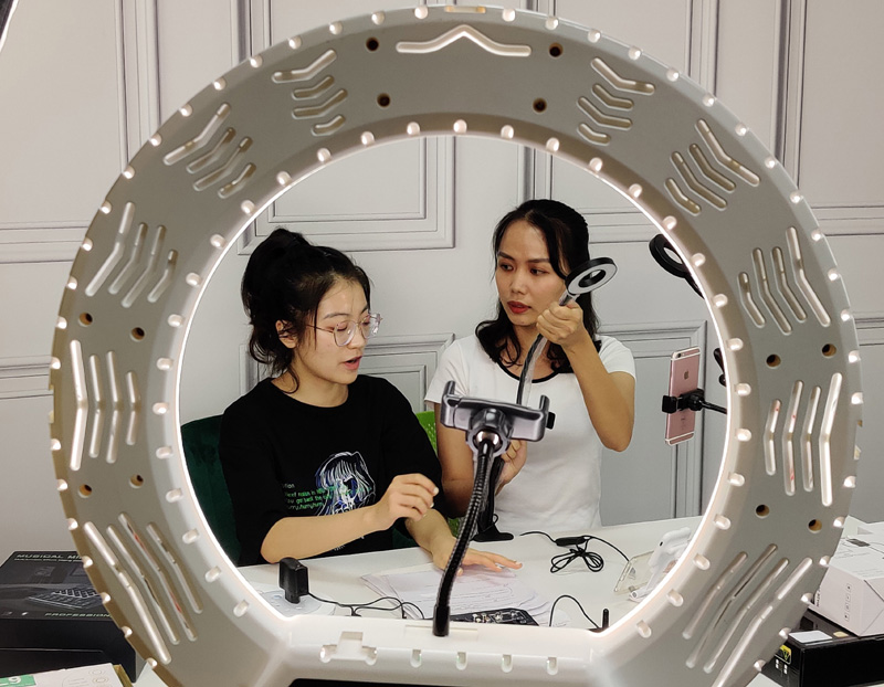 8月25日,广西外国语学院越南留学生邓氏仙(右)在广西自贸试验区南宁片区一家跨境电商企业直播人才孵化基地内进行直播。中国(广西)自由贸易试验区设立以来,紧紧围绕建设引领中国—东盟开放合作高标准高质量园区的发展目标,深耕“试验田”,有效激发市场活力、促进产业落地生根,为广西经济高质量发展和扩大开放注入了新动能。新华社记者 雷嘉兴 摄.jpg